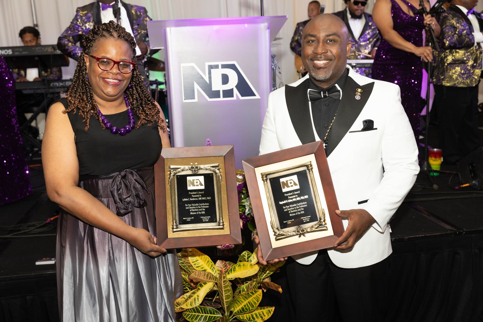 Two NDA award recipients holding their plaques at the awards ceremony